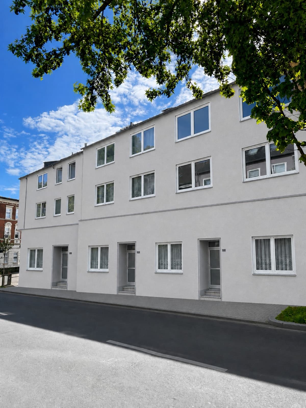 Frisch gestrichenes Mehrfamilienhaus unter blauem Himmel in Dortmund-Lütgendortmund